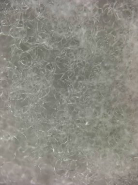 Karmaşık detaylar ve pürüzsüz, parlak bir yüzey gösteren beyaz sentetik iplik dokusunun yakın çekimi. Soyut tekstil fotoğrafçılığı için mükemmel..