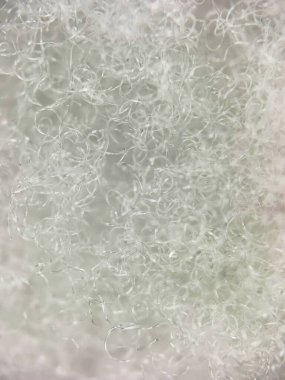 Beyaz sentetik lifin makro görüntüsü ince bir doku ve pürüzsüz bir görünüm taşır. Soyut, modern tasarım ve doku resimleri için mükemmel..
