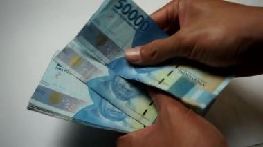 Elindeki 50 bin rupi ile harika görünüyor.