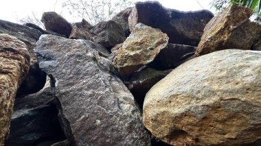 Büyük, kırmızımsı kahverengi kaya yığınının yakın açılı görüntüsü.