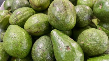 Dokulu yüzeyde taze yeşil avokadolar..