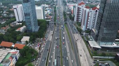 Yoğun trafiği, gökdelenleri ve çevre binaları olan işlek bir şehir otoyolunun insansız hava aracı görüntüleri. DKI Jakarta, Endonezya - 10 Januari 2025