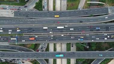 Arabalar, kamyonlar ve otobüslerle yoğun bir otoyol kavşağının havadan görüntüsü. Yoğun trafik akışı.