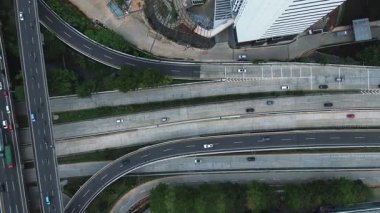 Yoğun bir otoyol kavşağının çeşitli araçlarla tepe noktası. Arabalar, kamyonlar ve otobüsler birden fazla şeritte seyahat ederler..