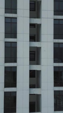 Modern bir binanın dış görüntüsü, pencereleri ve ön cephe detaylarını gözler önüne seriyor. Temiz çizgiler ve mimari tasarım.