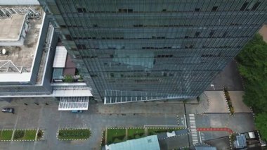 Modern cam gökdelenin ve çevresinin insansız hava aracı görüntüleri, mimari ve peyzaj sergiliyor. DKI Jakarta, Endonezya - 22 Ocak 2025