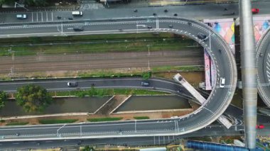 Şehrin üst geçidinin yüksek açılı görüntüsü, demiryolu rayları, kanal ve çevre kentsel manzara. Trafik sorunsuz akıyor..