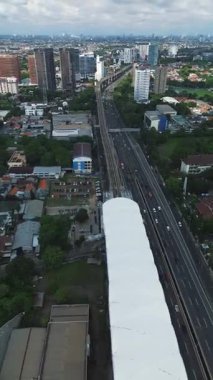 MRT istasyonu, otoyol ve şehir manzarasının yüksek açılı görüntüsü. Arabalar ve binalar görünür..