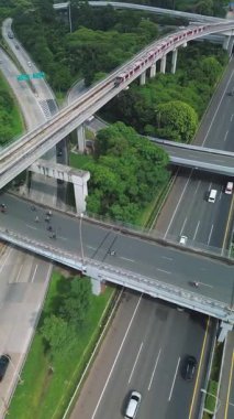 Yoğun bir otoyolun üzerinden geçen Jakarta 'nın Hafif Demiryolu Transit' inin (LRT) hava görüntüleri. Aşağıda arabalar ve motosikletler görülebilir..