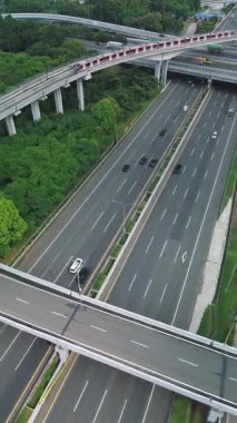 Yoğun bir otoyolun üzerinden geçen Jakarta 'nın Hafif Demiryolu Geçidi' nin (LRT) havadan görüntüsü. Arabalar ve kamyonlar aşağıda seyahat eder..