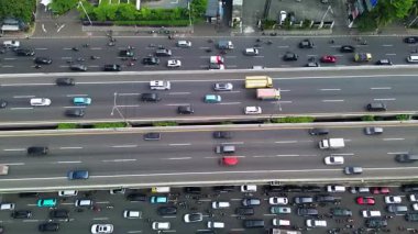 Karayolu trafiğinin insansız hava aracı görüntüsü. Arabalar, motosikletler ve birden fazla şerit boyunca hareket eden bir otobüs. Şehir ayarları.