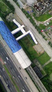 Bir Light Rail Transit (LRT) istasyonu, karayolu trafiği ve çevre kent manzarasının genel görünümü. İnsansız hava aracı görüntüleri.