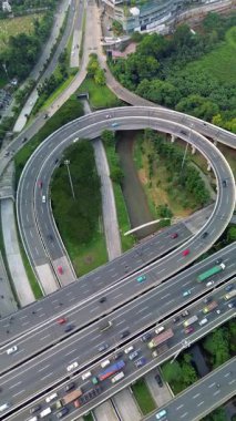 Yoğun trafik akışı, yemyeşil bir nehir ve yüksek açılı bir otoyol kavşağı manzarası..