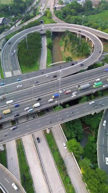 Yoğun bir otoyol kavşağının yukarıdan çekimleri çeşitli araçlar, yemyeşil ve bir nehir....