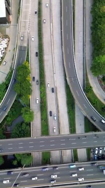 Otoyol kavşağının uzaktan kumandalı görüntüleri, hareket eden arabalar, görünür yeşil alanlar..