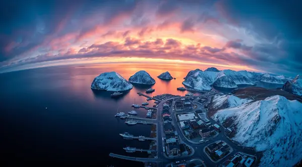 Kışın gün batımında Karlı Kıyı Kasabası ve Dağlarının Hava Görüntüsü