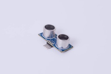 Malang, 24 Mart 2025. Beyaz zemin üzerinde HC-SR04 ultrasonik sensör modülünün yan görüntüsü. Arduino, robotik, engelli algılama, DIY elektronik sensörü.