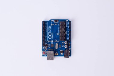Malang, 24 Mart 2025. Beyaz arkaplandaki Arduino Uno mikro kontrol panelinin üst görüntüsü. DIY elektronik, robotik, gömülü sistem, prototip donanımı, kodlama için açık kaynak platformu.
