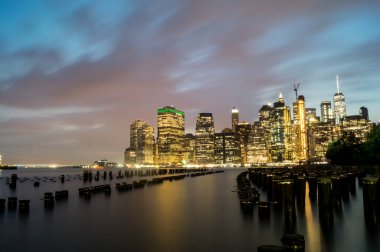 Geceleri New York Manhattan 'da gökdelenler ve nehirlerle