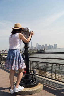 Özgürlük Adası 'nda dürbünlü bir kadın.