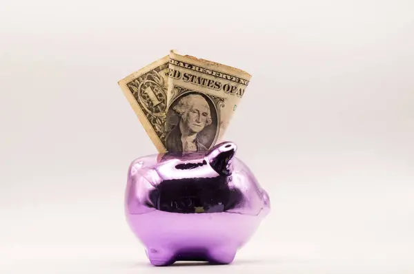 Beyaz bir arka planda kumbara ve dolar. kaydetme kavramı.