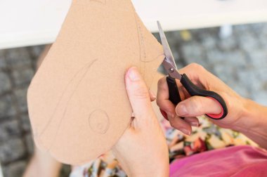 Öğretmen okula dönüş sanatı için karton kesiyor.