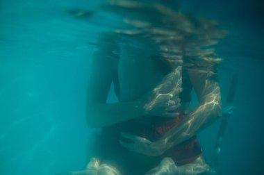 Oğluna sarılan bir annenin sualtı fotoğrafı.