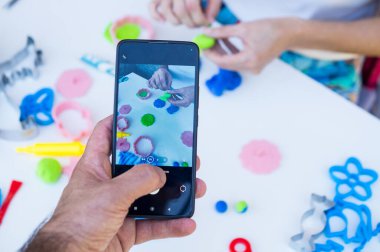 Çocuk akıllı telefondan oyuncak yapıyor, çocuk oyuncak yapıyor..