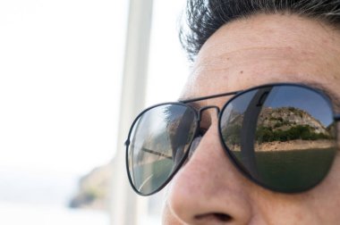 Arka planda bir dağ gölü manzarasına bakan adam.