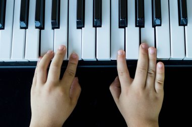 Baba oğul piyano çalıyorlar.