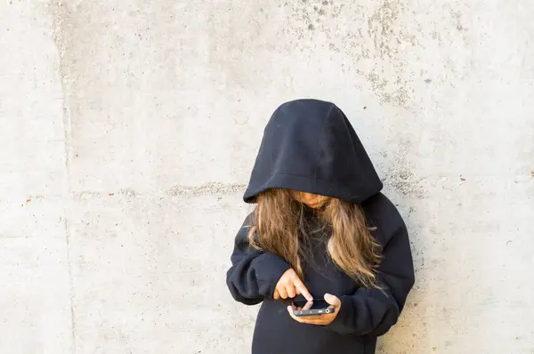 Siyah ceketli, beyaz tişörtlü ve kapüşonlu genç kız.