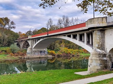 Owicim, Polonya 26 Ekim 2024: En Çok Piastowski olarak bilinen beton kemer köprüsü Soa Nehri 'ni yansımaları ve sonbahar ağaçlarıyla geçiyor