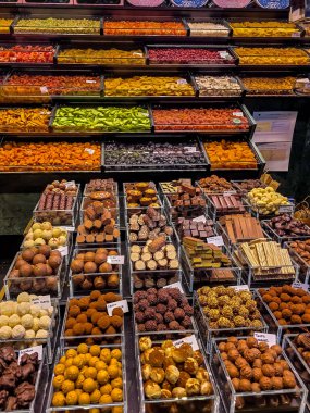 Barcelona 'daki La Boqueria Market' te geleneksel bir şeker dükkanında canlı bir çikolata ve kurutulmuş meyve seçimi sergilenmektedir.