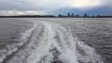 Kuğu Nehri 'nde seyreden bir teknenin bıraktığı su izi. Perth' in ufuk çizgisi uzakta..