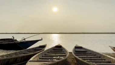 Gün batımında nehir kıyısında tekneler