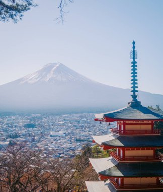 Fujiyoshida, Japonya - 10 Aralık 2023: Fujis Dağı karla kaplı zirveye karşı Chureito Pagoda manzarası.