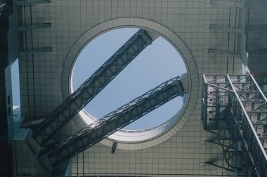 Osaka, Japonya - 3 Mayıs 2024: Umeda Gökyüzü Binası 'nın dairesel açıkları, geometrik simetrisi ve modern yapı elemanlarının büyüleyici bir görüntüsü. Bu resim, temiz çizgilerle yenilikçi tasarımı ve kentsel karmaşıklığı vurgular..