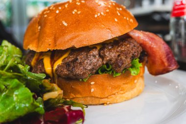 Ahşap bir masada sığır pirzolası ile nefis biftek burgeri..