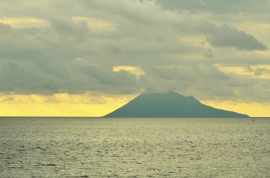 Bulutlu öğleden sonra atmosferi Manado Dağı 'nın batımını kaplıyor.