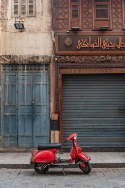 Kahire, Mısır, 26 Kasım 2022. Çok havalı kırmızı Vespa motosikleti Kahire 'nin İslami Mahallesi' nde, ünlü Han el Khalili Çarşısı 'nın yanında park edilmiş.. 