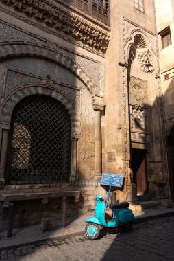 Kahire, Mısır. 21 Aralık 2022 'de Katkhuda Sabil-Kuttab' ın dışında, El Muizz Caddesi 'nde El Halili Çarşısı' nda, Mısır 'ın İslami Kahire' nin eski bölümünde, El-Halili Çarşısında Vespa motorsikleti.. 