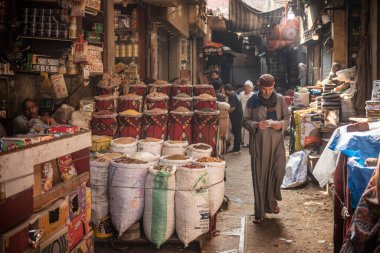 Kahire, Mısır. 1 Temmuz 2024. Baharat pazarının dar sokaklarında yürüyen Mısırlı bir adam Han El Khalili Çarşısı, Al Hussein, Kahire, Mısır yakınlarındaki yerli halk ve turistler arasında popüler yoğun bir çarşı.. 