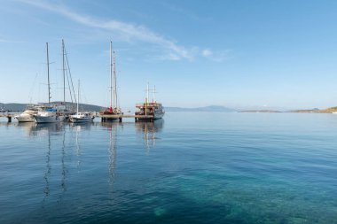 Bodrum, Mugla, Türkiye. 21 Nisan 2022, Türkiye 'nin batısındaki Ege kıyısında popüler bir liman ve turizm merkezi olan Bodrum limanında demirlemiş yatların serin sabah ışığı  