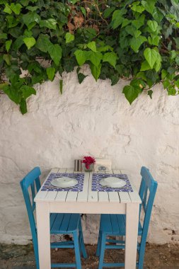 Türkiye 'nin Ege kıyısındaki Bodrum eski kenti, Türkiye' nin popüler turizm beldesi Bodrum 'da gölgeli bir yan sokakta oldukça mavi ve beyaz kafe restoranı masası