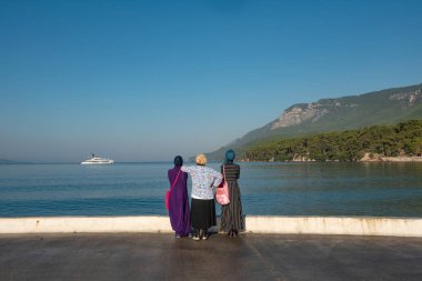 Akyaka, Mugla, Türkiye. 8 Eylül 2022 'de Türkiye' nin kıyı kenti Akyaka 'ya gelen kadın ziyaretçiler, körfezde demirli güzel manzara ve pahalı yata hayran kaldılar. Türk kıyısı, Mugla. 
