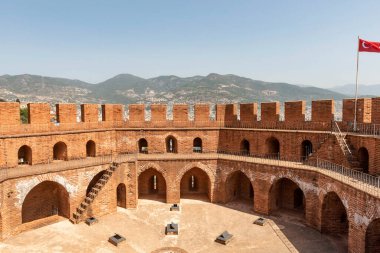 Alanya, Türkiye. 7 Nisan 2021 Seljuk döneminden kalma Kızıl Kule ya da arka planda Taurus Dağları olan Alanya limanına bakan Kizi Kule siperleri.. 