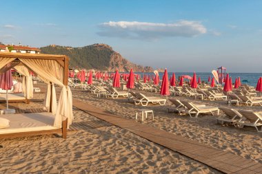 Alanya, Türkiye. Türkiye 'nin Akdeniz kıyısındaki Türkiye tatil beldesi Alanya' daki Kleopatra Sahili 'nde 9 Temmuz 2024 Güneş yatakları ve pembe güneş gözlüğü. 