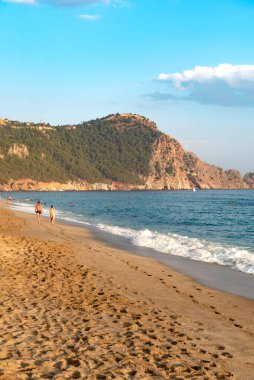 Türkiye 'nin Akdeniz kıyısındaki Türkiye tatil beldesi Alanya' da, gün batımında boş bir Kleopatra plajı boyunca yürüyen bir çift görülüyor.. 