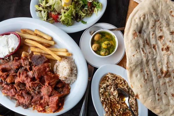 Bir tabak İskender ya da Bursa kebabı, Türk mezesi ve geleneksel ekmek. Türkiye 'de tipik yerel mutfak 