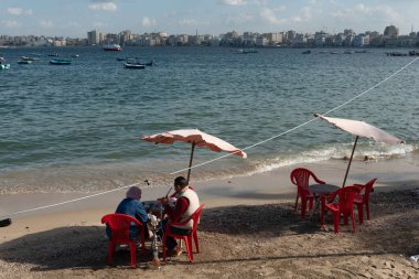 İskenderiye, Mısır. 1 Aralık 2022 'de Mısır' ın kuzeyindeki İskenderiye şehrinin Akdeniz sahilinde bir Mısırlı çift oturuyor.. 